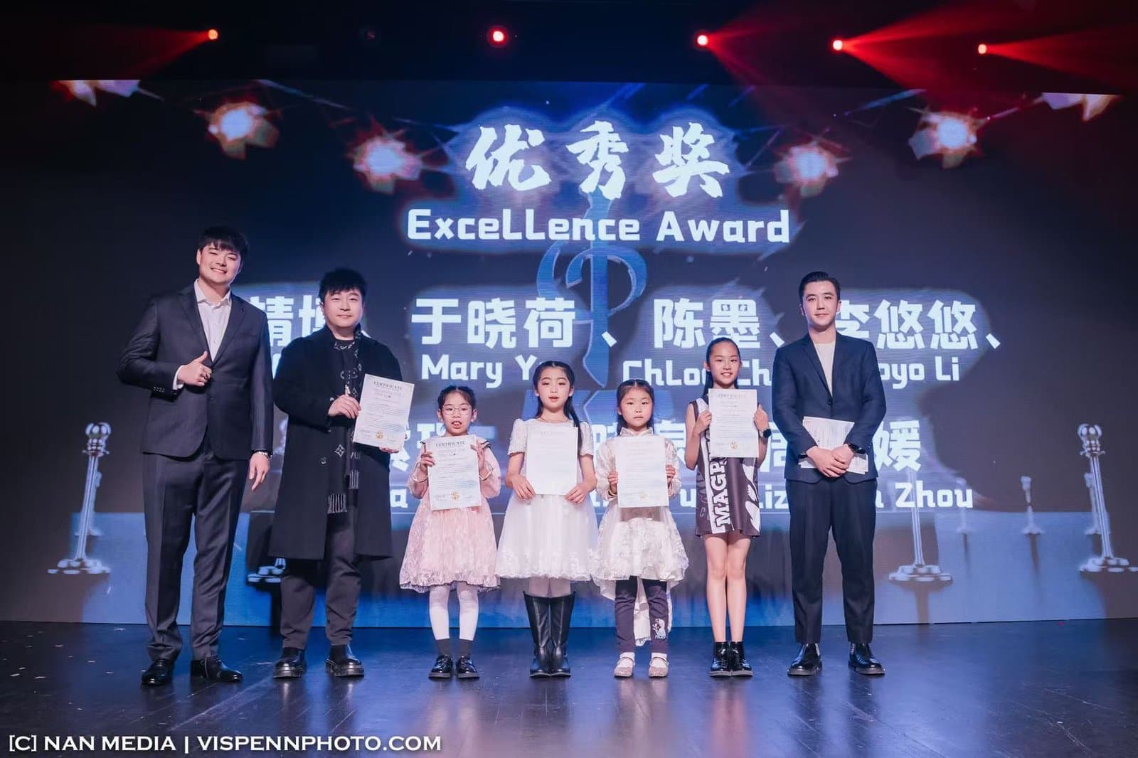 Students on stage under an Excellence Award screen at a competition ceremony