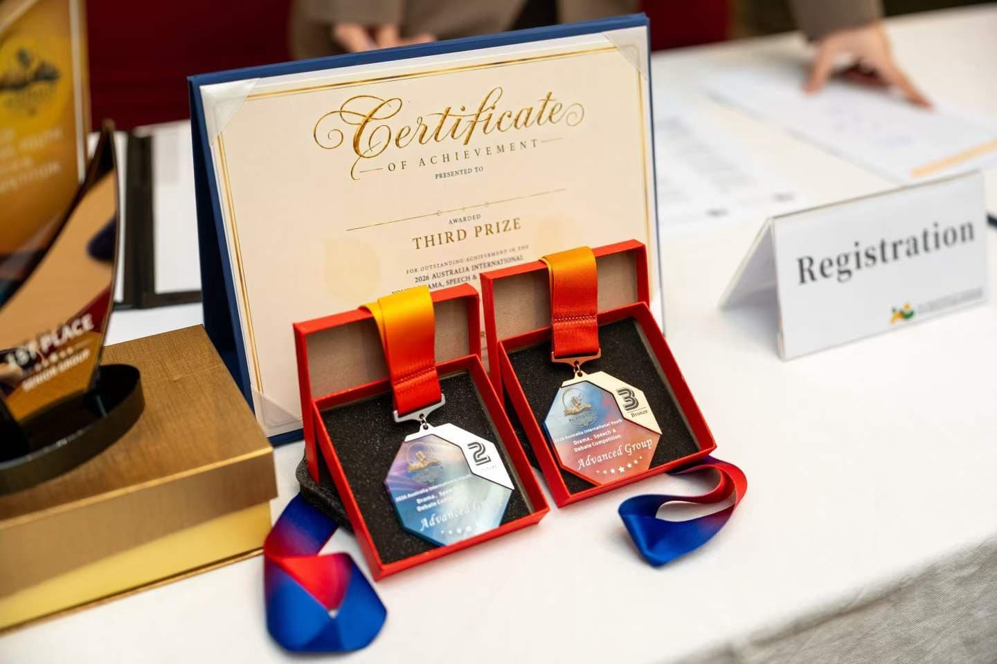 A third prize certificate beside two medals in their presentation box