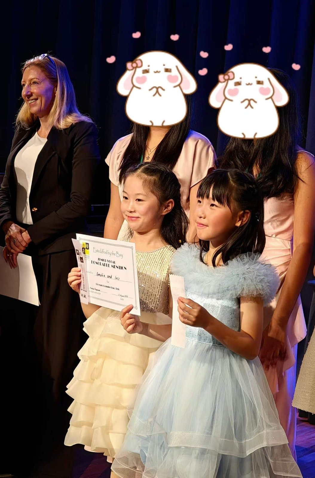 Two students with certificates beside an adjudicator after the results