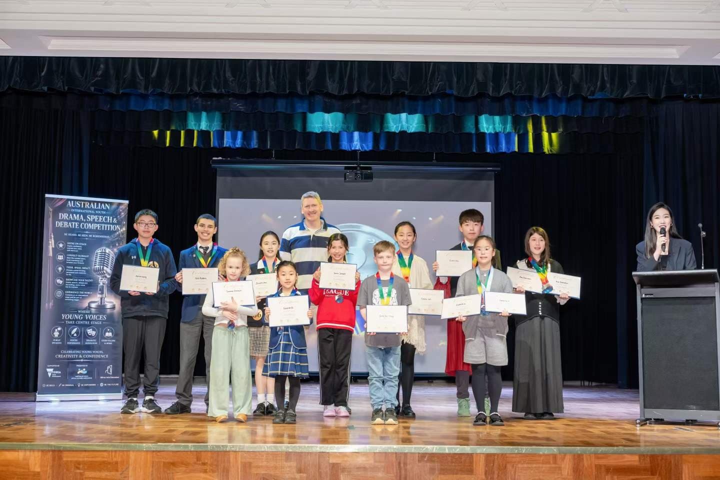 A second group of speech and debate competitors with certificates and medals