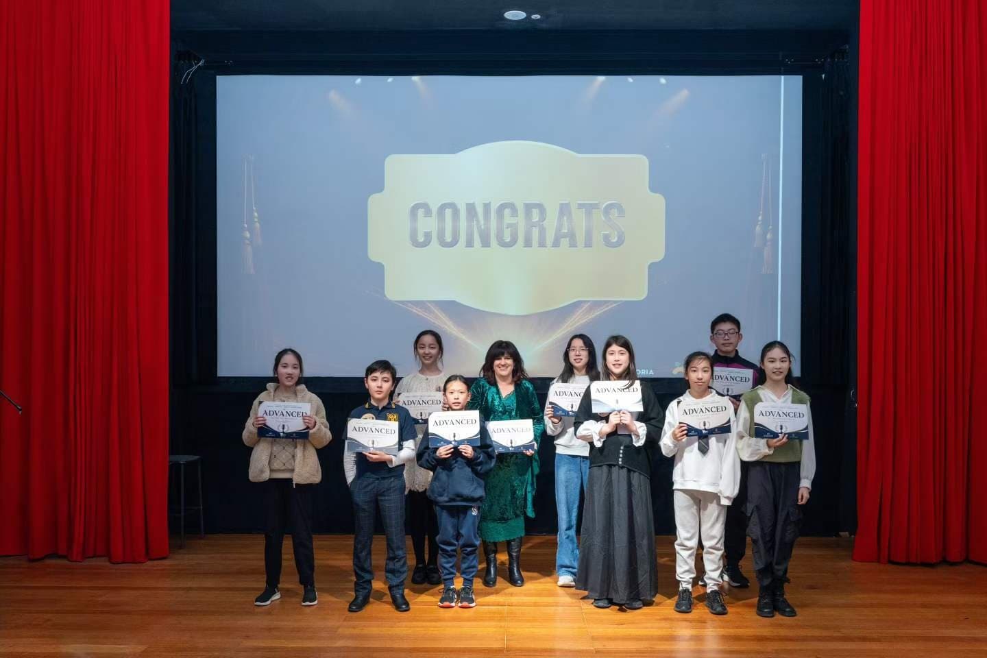 The competitors and their teachers gathered under a Congrats screen