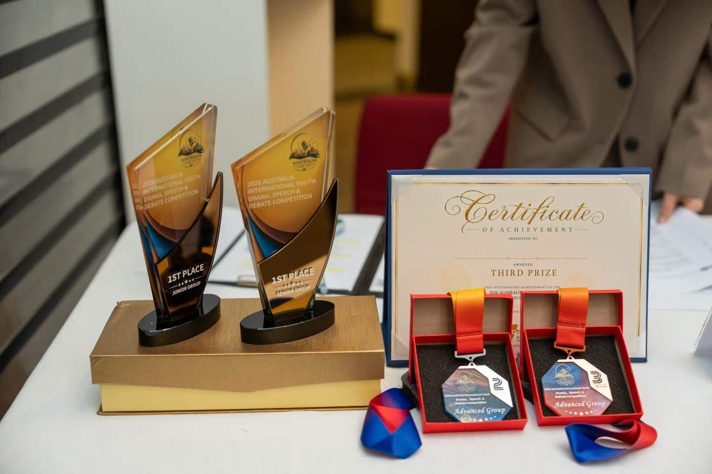 Two trophies, a certificate and medals laid out on the awards table