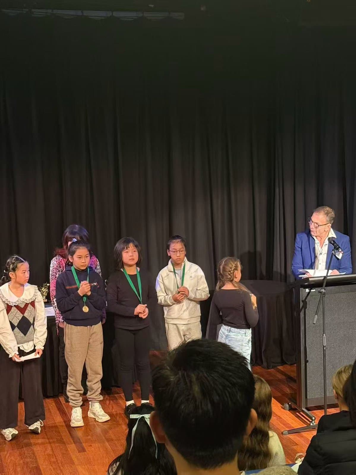 Students and the adjudicator on stage as the results are read